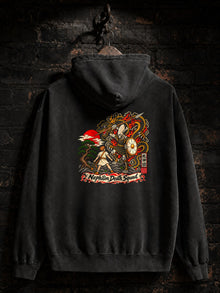 Pepper Nephilim Slayer Embroidered Hoodie hanging on a brick wall, back view: printed David vs Goliath design; only the front chest logo is embroidered