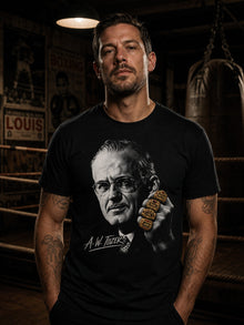 Man wearing the black A.W. Tozer Gospel Heavyweight T-shirt in a dim old boxing gym