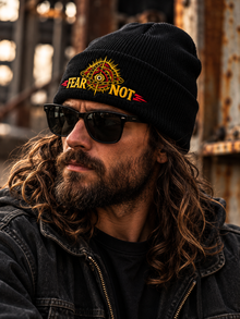 Fear Not Beanie by TopLobsta, black cuffed beanie, earlier gold and red embroidery sample, model view