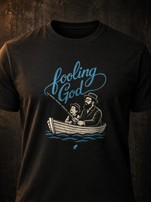 Close front view of Fooling God Christian fishing tee graphic on black shirt