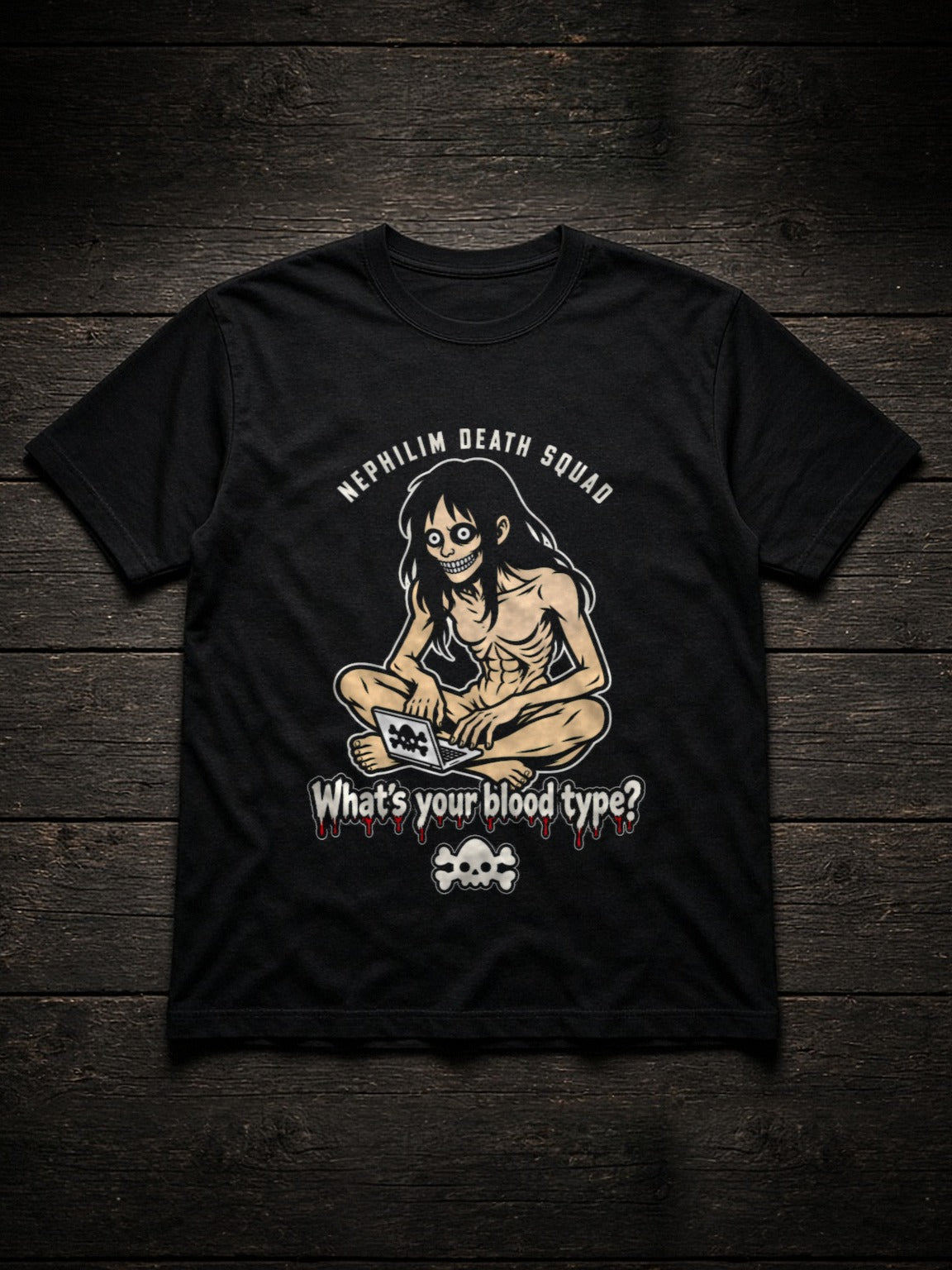Black NDS What's Your Blood Type? Tee (Tultex 202) flat lay on dark wood: NEPHILIM DEATH SQUAD arched over a gaunt long-haired figure grinning over a laptop, the dripping red What's your blood type? headline and a cream skull and crossbones, printed center chest