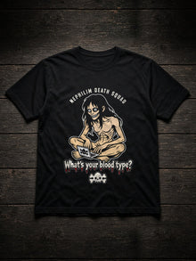 Black NDS What's Your Blood Type? Tee (Tultex 202) flat lay on dark wood: NEPHILIM DEATH SQUAD arched over a gaunt long-haired figure grinning over a laptop, the dripping red What's your blood type? headline and a cream skull and crossbones, printed center chest