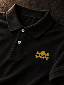 Yellow NDS skull logo embroidery detail on black polo shirt