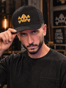 Man wearing the black Nephilim Death Squad logo trucker hat with the gold skull embroidery