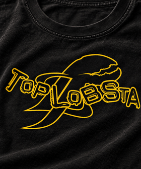 Close-up of yellow TopLobsta wordmark and claw logo on charcoal tee