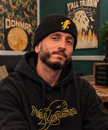 Man wearing black TopLobsta logo beanie and yellow claw hoodie
