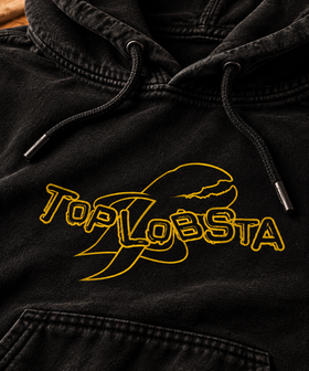 Close-up of yellow TopLobsta wordmark and claw on black hoodie
