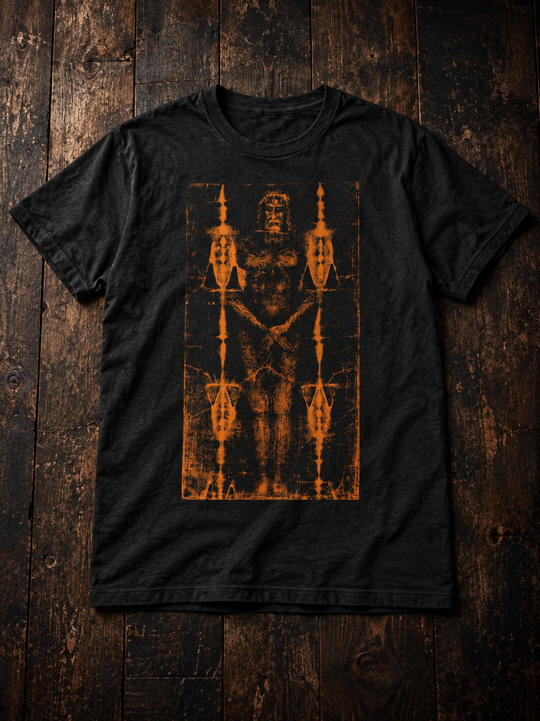 Shroud of Turin T-Shirt by Nephilim Death Squad: black tee with distressed orange shroud relic print, dark wood flat lay