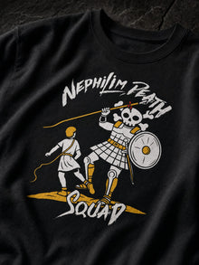 Close-up of the Skull of Goliath print on a black Nephilim Death Squad T-shirt: young David with a sling facing an armored skeleton giant, yellow and white ink