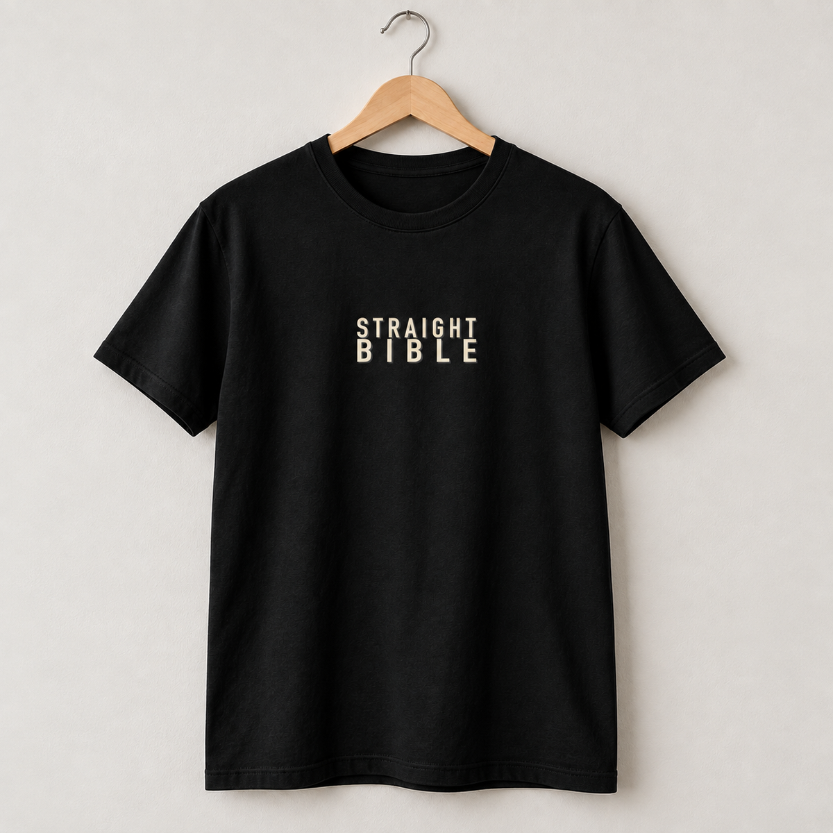 Straight Bible new-logo black T-shirt on a hanger, front view with cream STRAIGHT BIBLE chest text