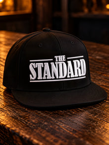 The Standard embroidered black snapback hat with white THE STANDARD wordmark