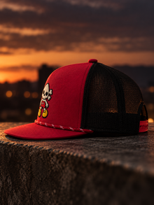 Toon Nephy embroidered red and black rope trucker hat, side profile at sunset